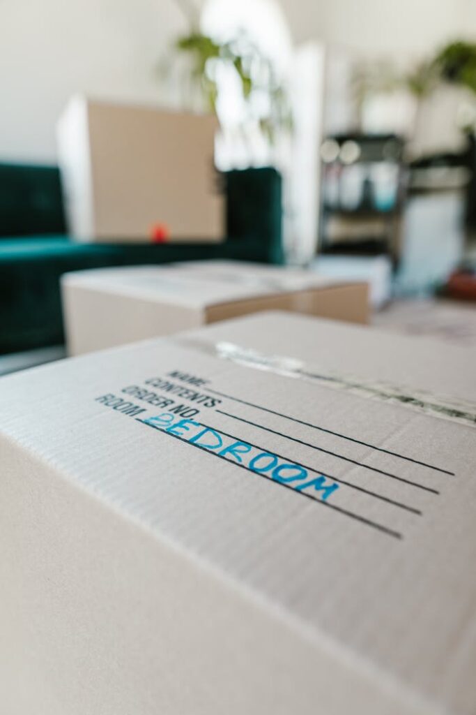 pexels photo 7464509 Packed cardboard box labeled 'Bedroom' indoors, ready for moving.
